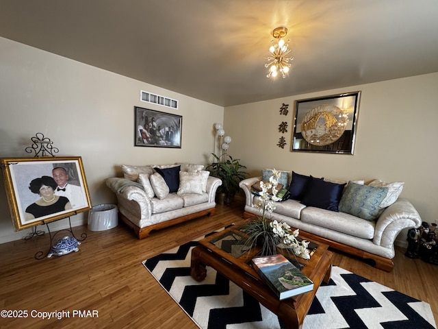 living room featuring a chandelier, wood finished floors, and visible vents