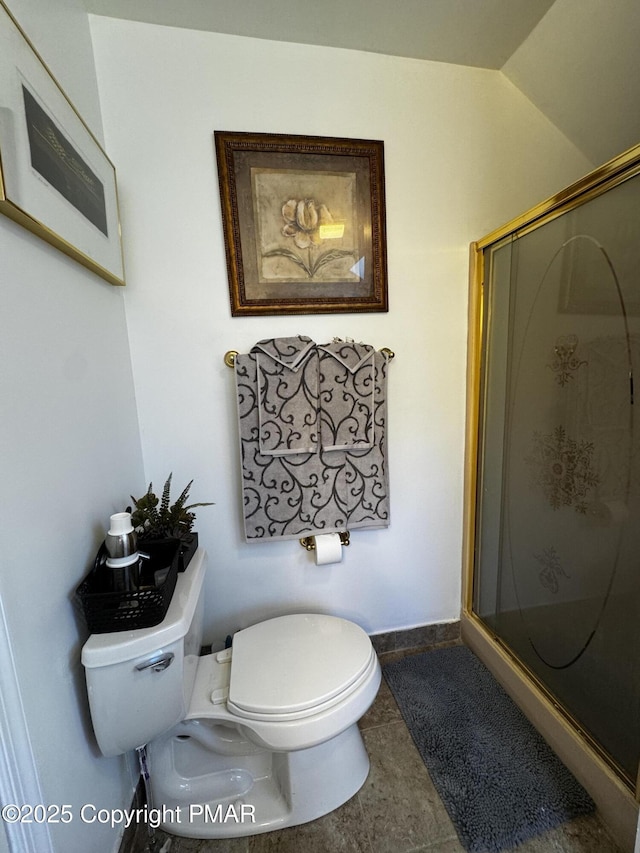 bathroom with toilet, a shower stall, baseboards, and lofted ceiling