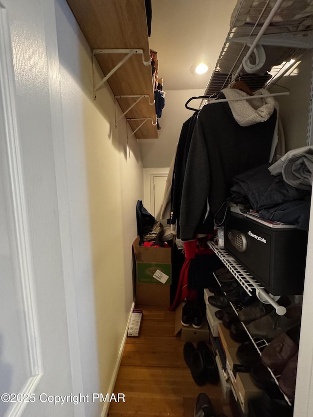 walk in closet with wood finished floors