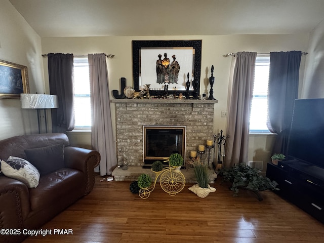 living area with a fireplace and wood finished floors