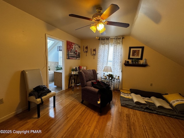 sitting room with vaulted ceiling, ceiling fan, wood finished floors, and baseboards