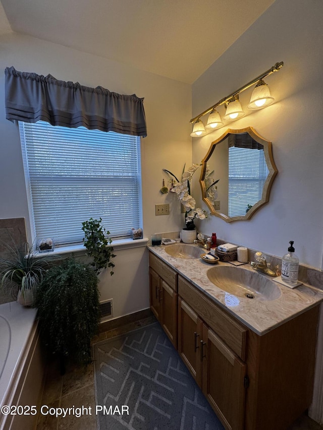 full bath with double vanity, a tub, visible vents, and a sink