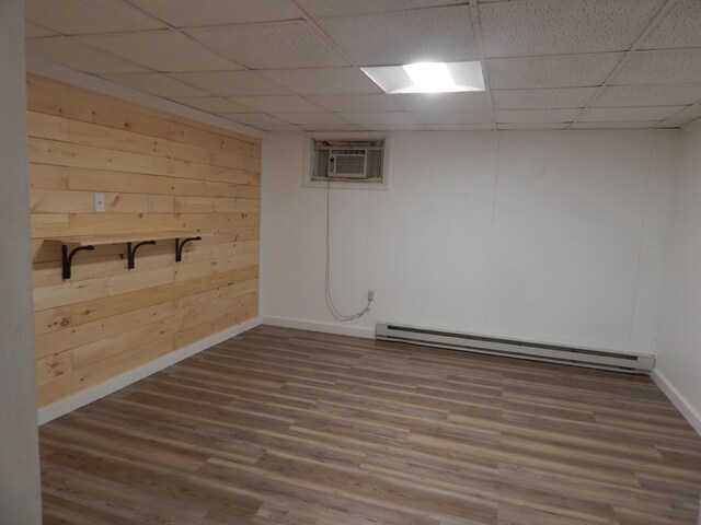 3277 State St, White Haven, PA 18661 - finished below grade area with a paneled ceiling, a baseboard radiator, a wall mounted air conditioner, and wood finished floors