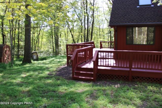 wooden terrace featuring a yard, a shed, and an outdoor structure