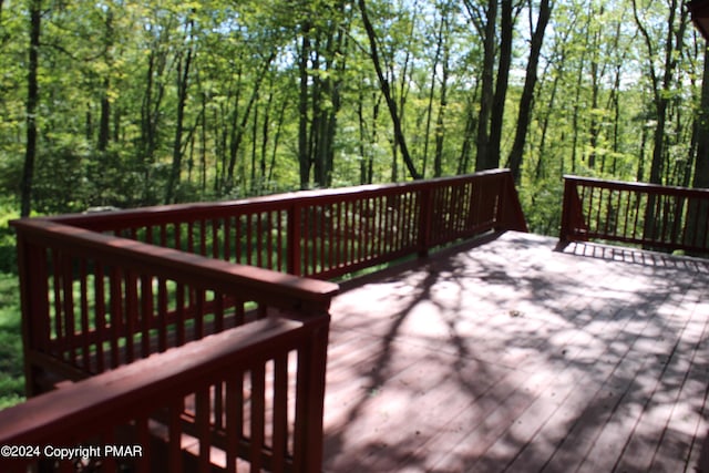 wooden deck with a wooded view