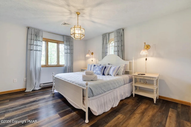 bedroom with a baseboard radiator, multiple windows, visible vents, and dark wood-type flooring