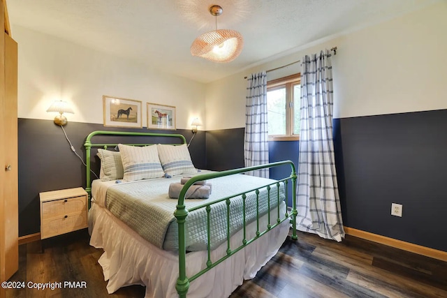 bedroom featuring wood finished floors and baseboards