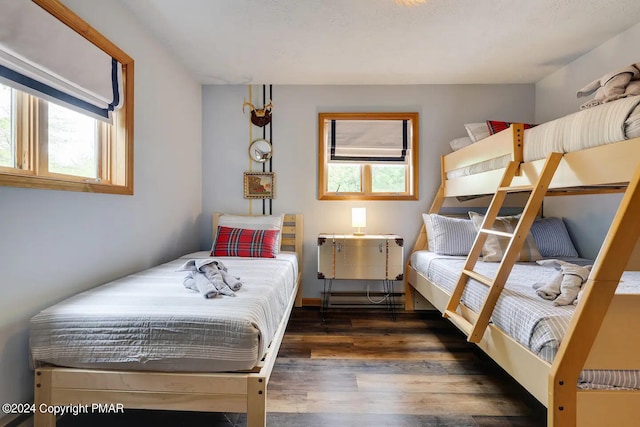 bedroom with multiple windows and wood finished floors