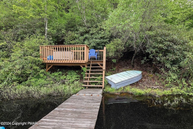 dock area featuring stairway, a wooded view, and a wooden deck