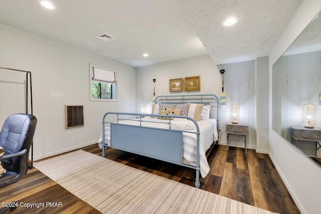 bedroom featuring wood finished floors, visible vents, and baseboards