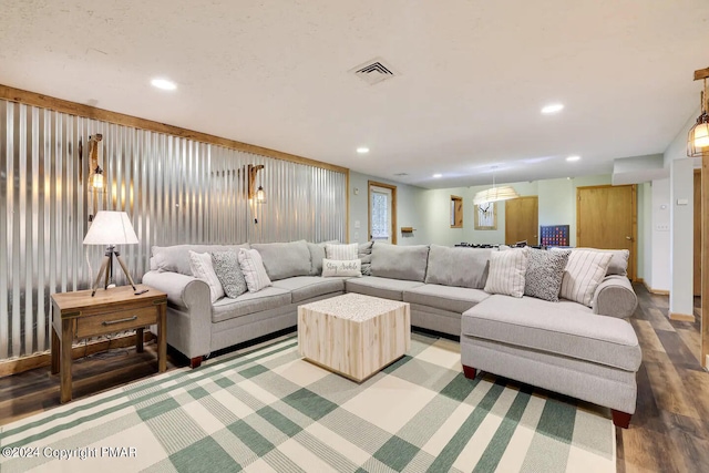 living room with recessed lighting, visible vents, and wood finished floors