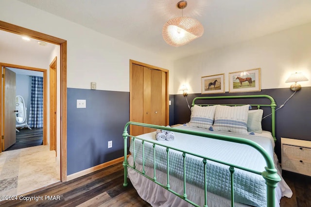 bedroom with a closet, baseboards, and wood finished floors