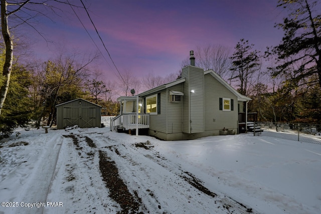 view of snow covered exterior featuring a shed