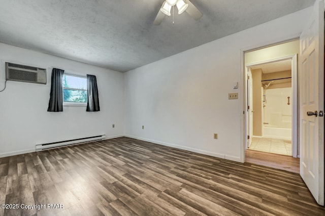 spare room featuring dark hardwood / wood-style flooring, a wall mounted AC, a textured ceiling, and a baseboard heating unit