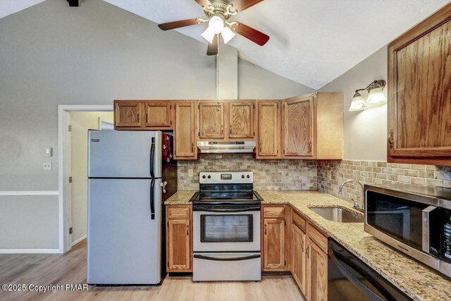 kitchen with lofted ceiling, sink, decorative backsplash, and stainless steel appliances