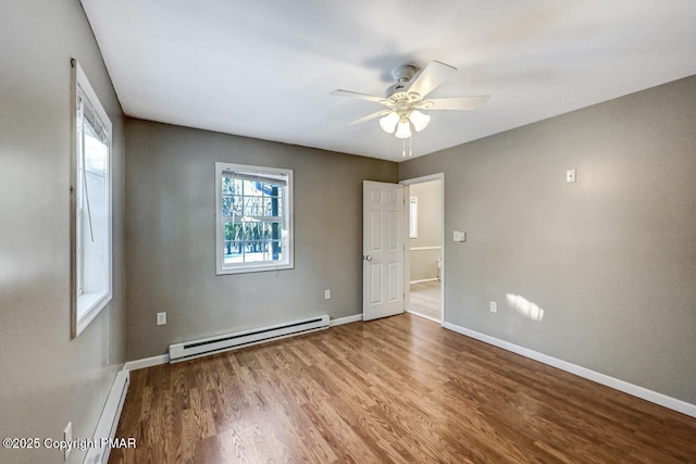 empty room with hardwood / wood-style floors, a baseboard radiator, and ceiling fan