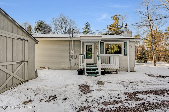 view of snow covered back of property