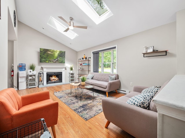 1533 Black Birch Way, Tobyhanna, PA 18466 - living area featuring a skylight, vaulted ceiling, wood finished floors, a lit fireplace, and a baseboard heating unit