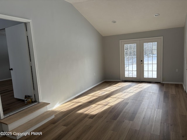 unfurnished room with lofted ceiling, french doors, wood finished floors, and baseboards