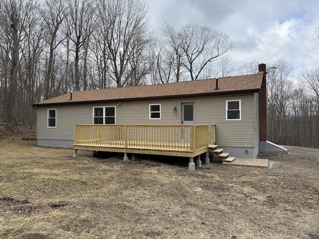 rear view of property with a wooden deck and a chimney