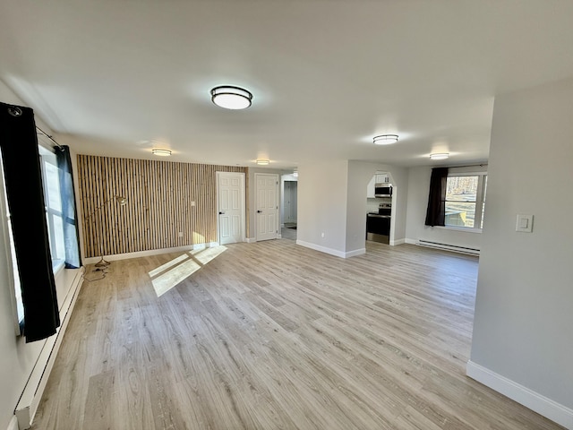 unfurnished living room featuring light wood-type flooring, baseboards, and baseboard heating