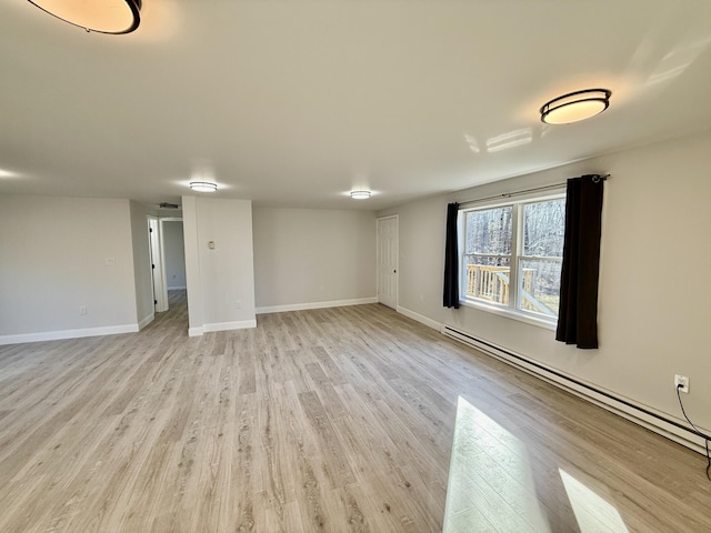 unfurnished room with baseboards, light wood-style floors, and baseboard heating