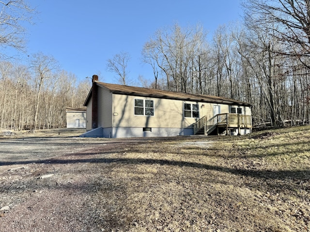 exterior space with a wooden deck and a chimney