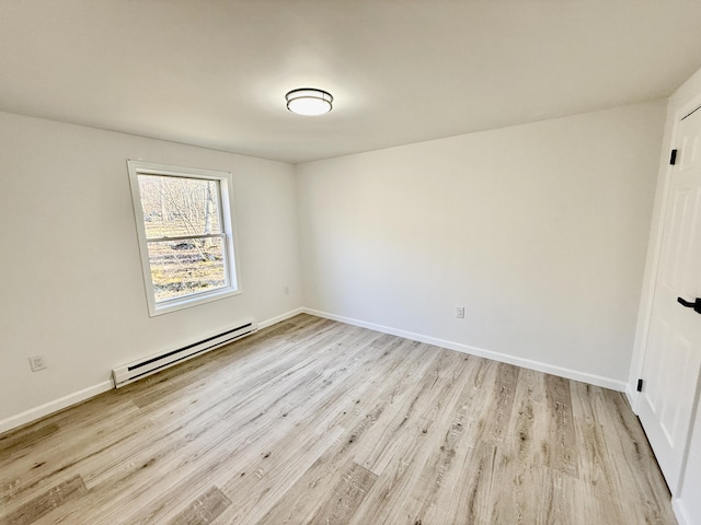 empty room with light wood-style flooring, baseboards, and a baseboard radiator