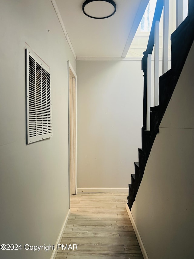 hall with baseboards, stairs, visible vents, and wood finished floors