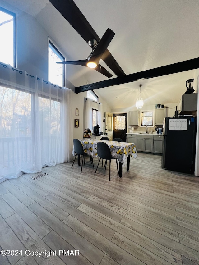 dining area with high vaulted ceiling, visible vents, a ceiling fan, light wood-style floors, and beam ceiling