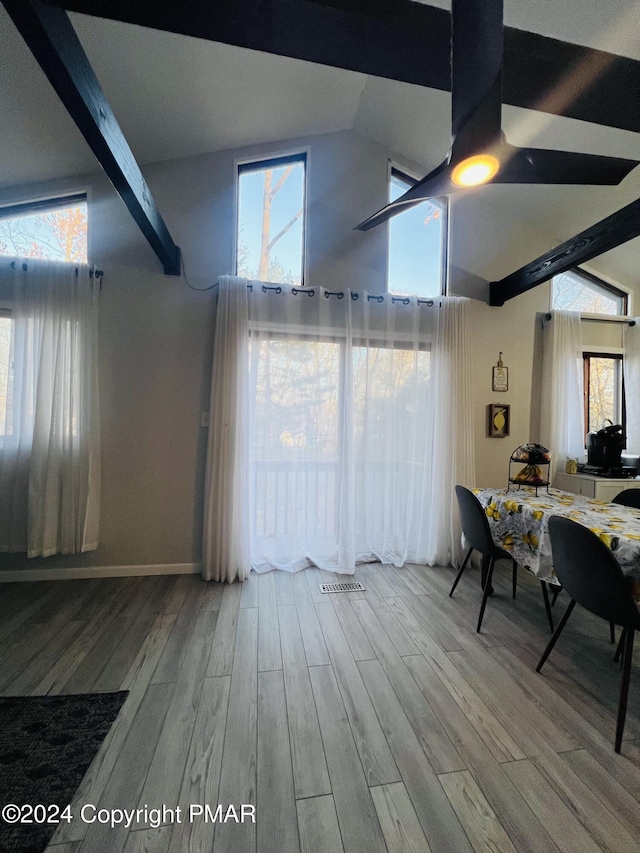 interior space with baseboards, ceiling fan, wood finished floors, high vaulted ceiling, and beam ceiling