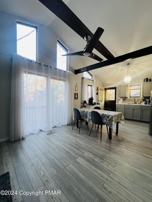 dining room featuring light wood-style floors, high vaulted ceiling, a notable chandelier, and beamed ceiling