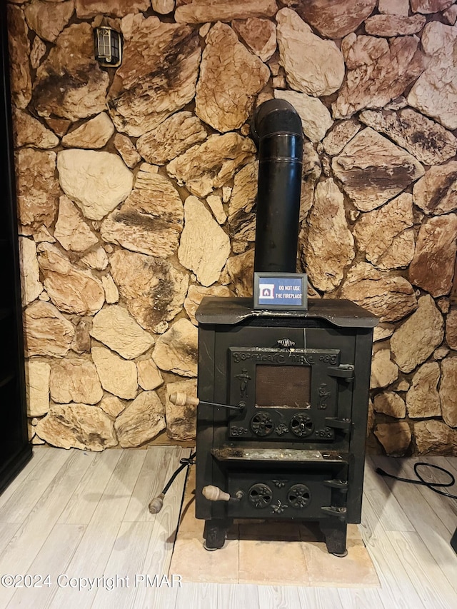 interior details with a wood stove and wood finished floors