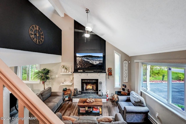 living area with a baseboard radiator, a fireplace, lofted ceiling with beams, and wood finished floors