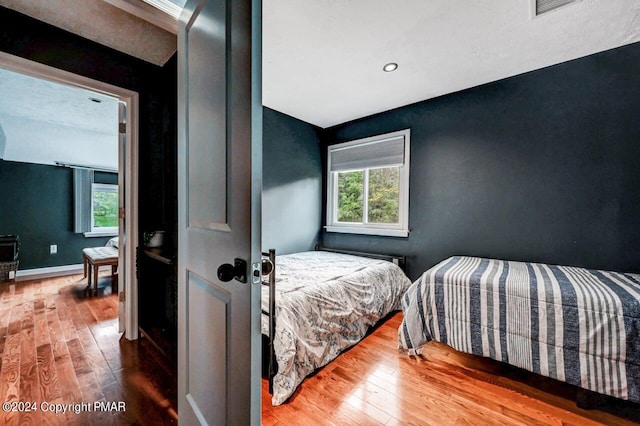 bedroom featuring wood-type flooring and baseboards