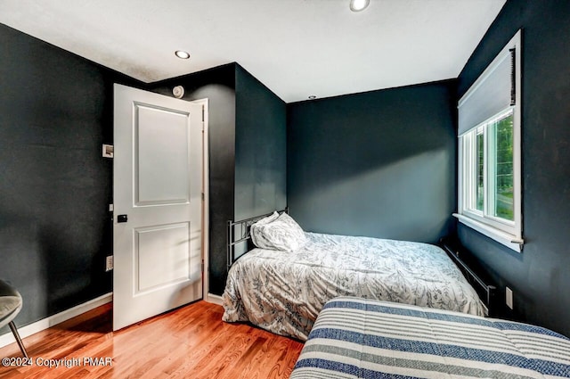 bedroom with recessed lighting, wood finished floors, and baseboards