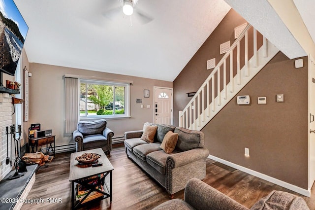 living area featuring stairs, a fireplace, vaulted ceiling, and wood finished floors