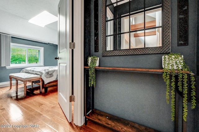 interior space featuring a skylight, baseboards, and wood finished floors