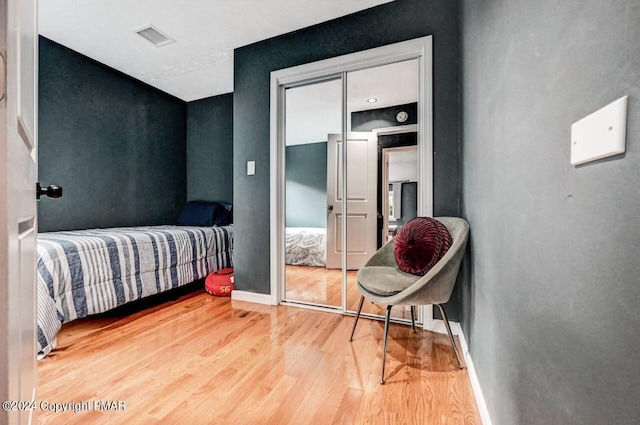 bedroom featuring visible vents, baseboards, and wood finished floors