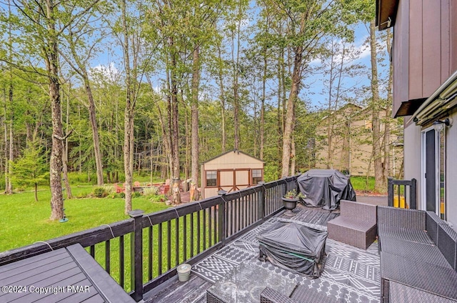 wooden deck featuring an outdoor structure, area for grilling, and a yard