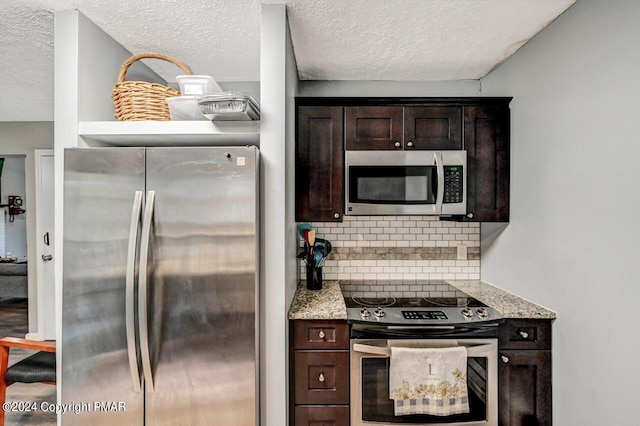 kitchen with light stone countertops, dark brown cabinetry, stainless steel appliances, and decorative backsplash