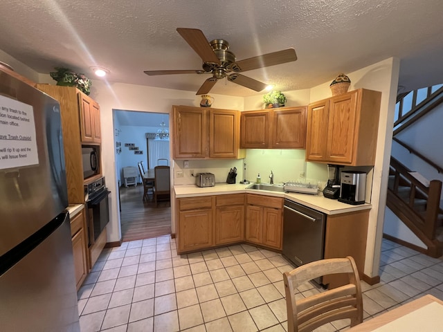 kitchen featuring light tile patterned floors, light countertops, a sink, a textured ceiling, and black appliances