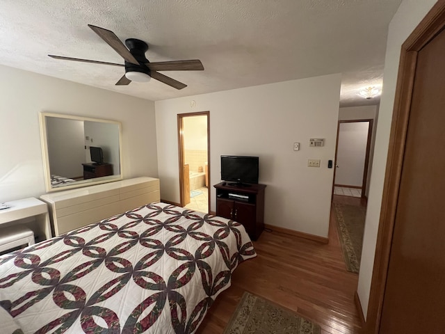 bedroom with a ceiling fan, connected bathroom, a textured ceiling, wood finished floors, and baseboards