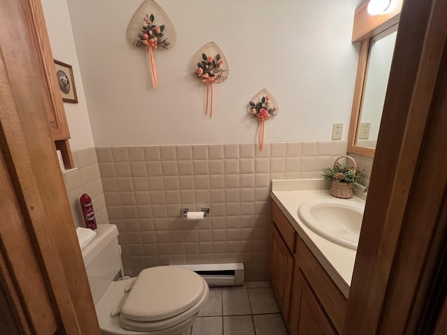 half bath featuring toilet, a wainscoted wall, tile patterned flooring, vanity, and tile walls