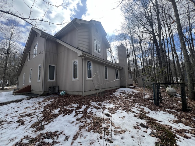 snow covered property with a chimney