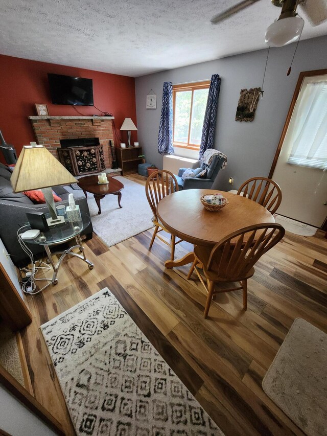 457 Maxatawny Dr, Pocono Lake, PA 18347 - living area featuring wood finished floors, ceiling fan, a fireplace, and a textured ceiling