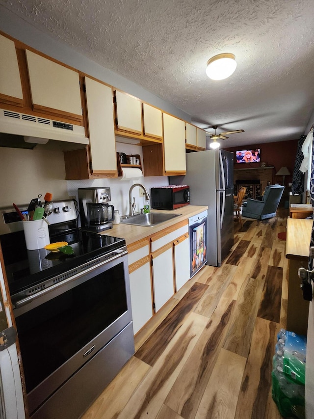 457 Maxatawny Dr, Pocono Lake, PA 18347 - kitchen with stainless steel appliances, under cabinet range hood, a sink, light wood-type flooring, and light countertops