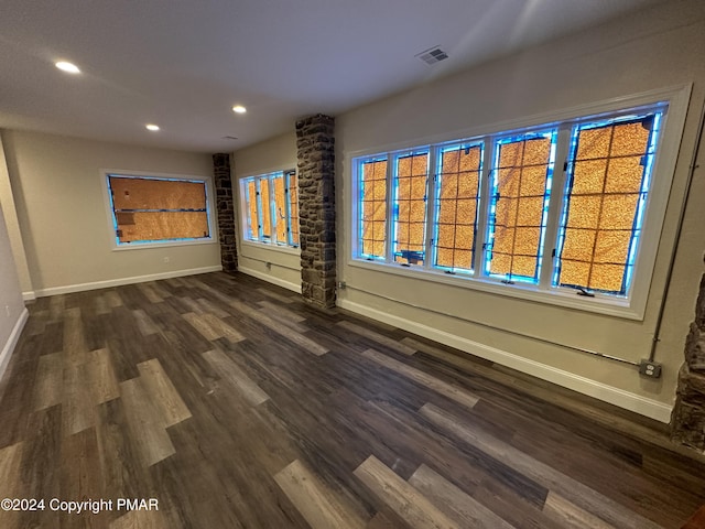 empty room featuring visible vents, dark wood-style floors, baseboards, and recessed lighting