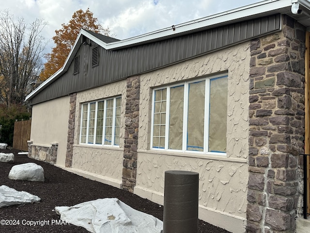view of home's exterior with stucco siding and stone siding