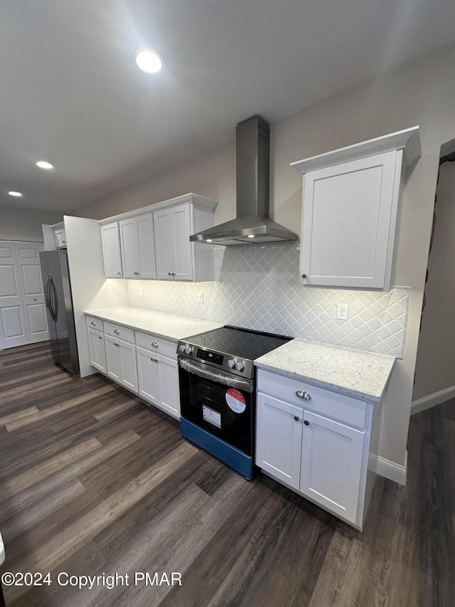 kitchen featuring white cabinetry, dark wood-style flooring, decorative backsplash, appliances with stainless steel finishes, and wall chimney exhaust hood